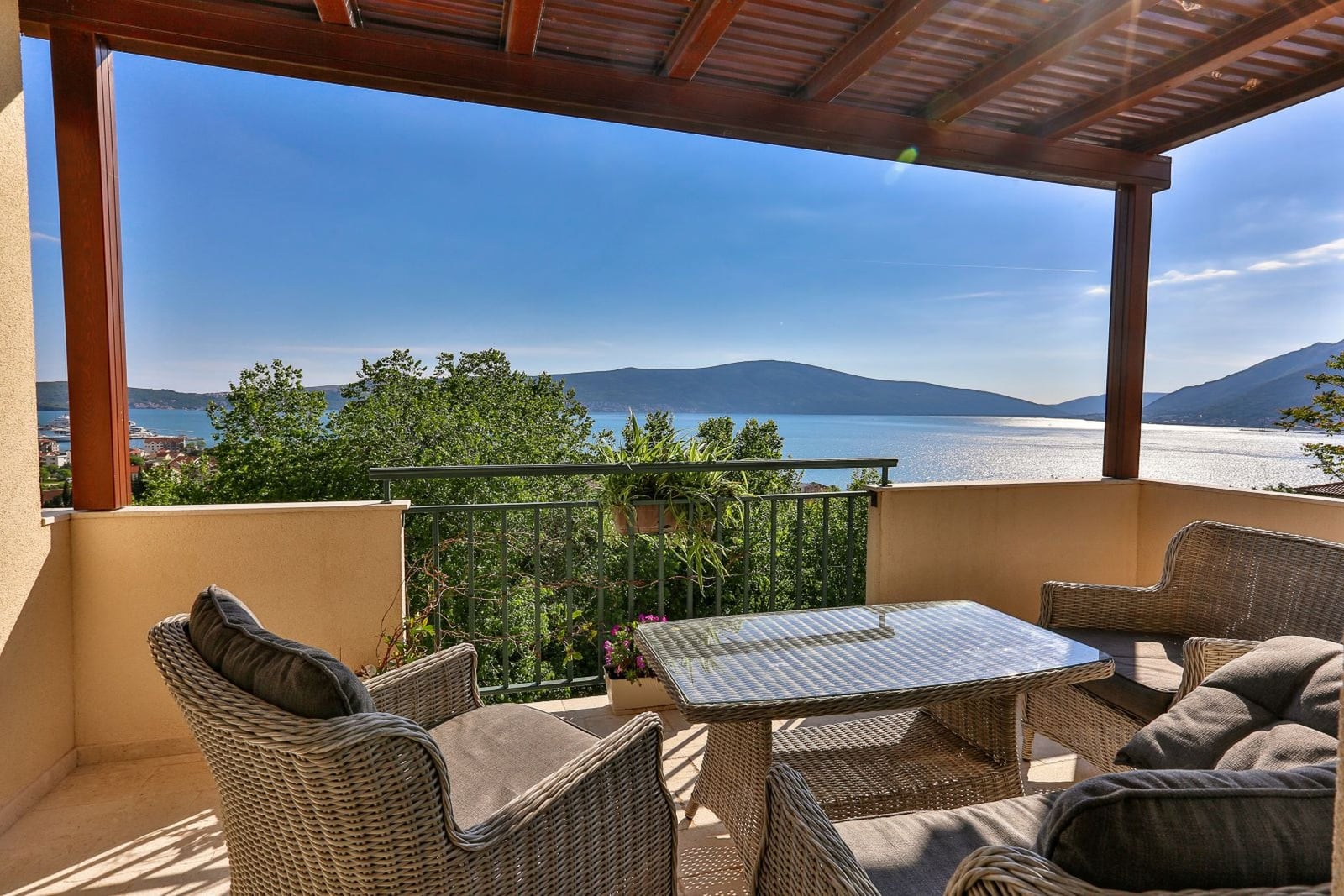 Terrace with wicker furniture and panoramic views of the sea and mountains, villa in Tivat, Montenegro.