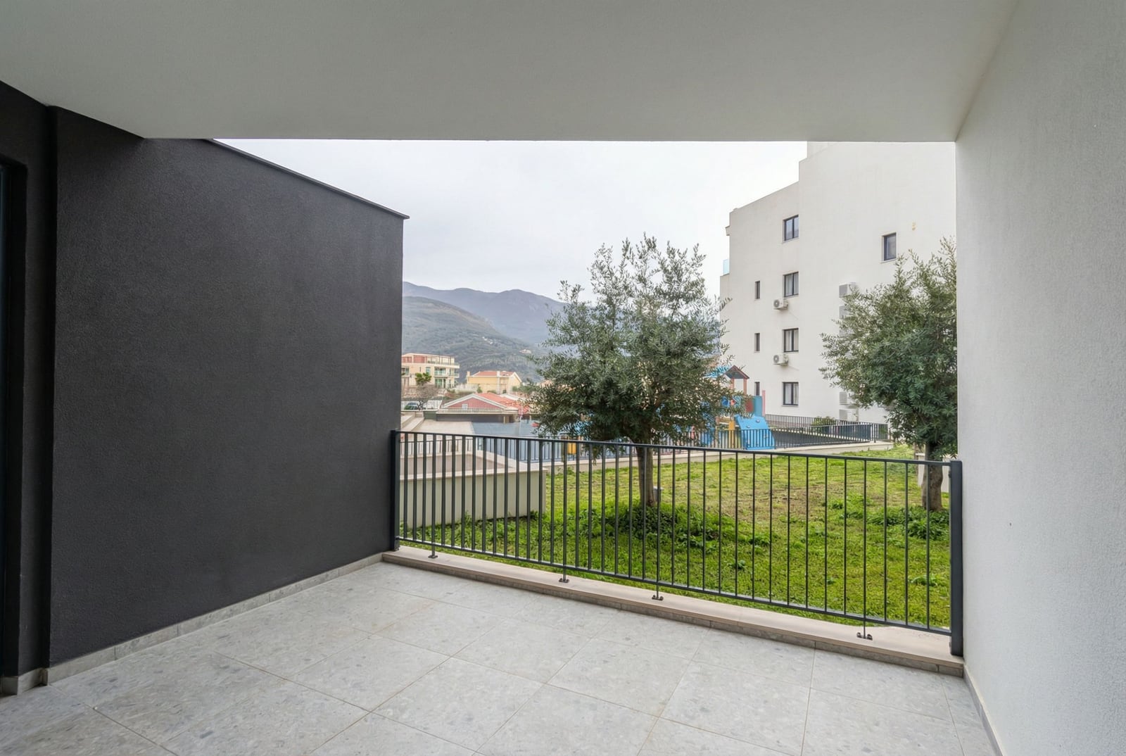 Spacious balcony with mountain views and a green courtyard in a modern apartment, Bečići, Montenegro.