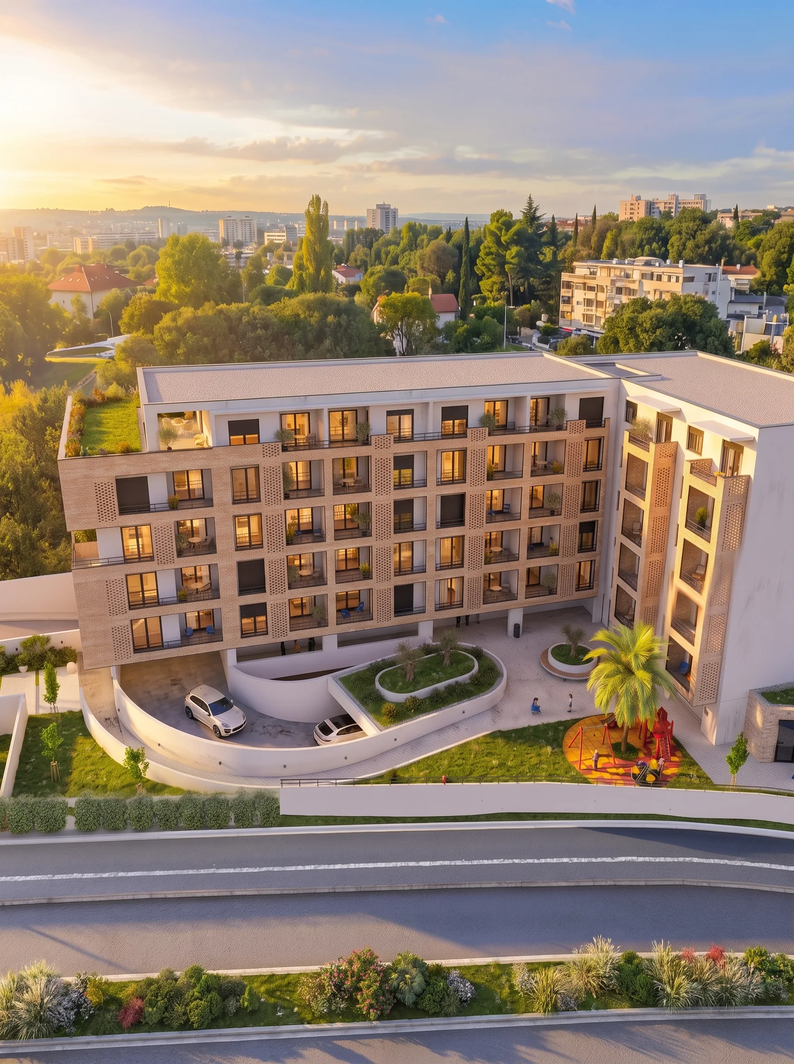 Aerial view of a modern multi-story residential building with balconies, green spaces, and a playground at sunset.