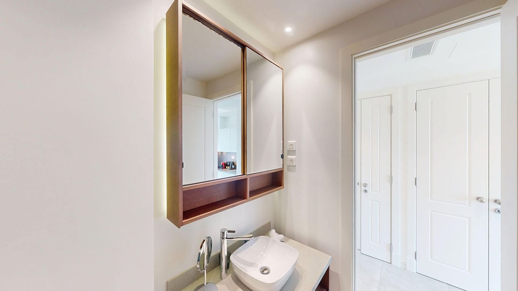 Modern bathroom with a mirrored cabinet and a countertop sink in an apartment in Luštica, Montenegro.