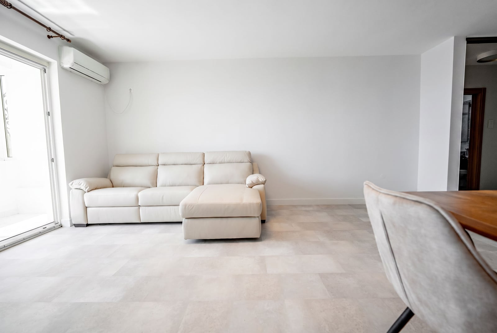 Bright living room with a white leather sofa and tiled floor in an apartment, Sveti Stefan, Montenegro.