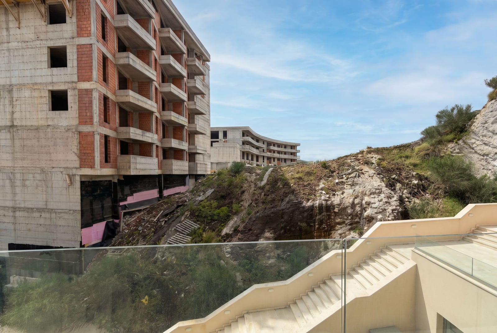 Residential complex under construction in Bečići, Montenegro: view of monolithic buildings and rocky landscape from the terrace.