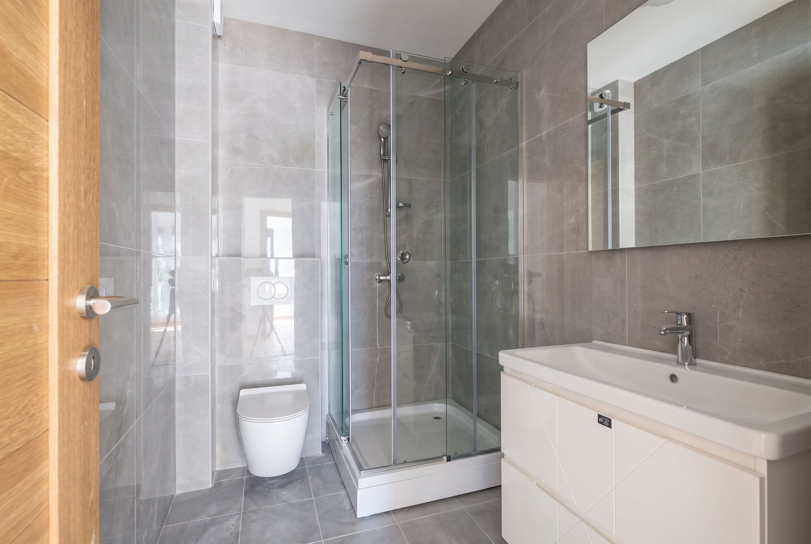 Modern bathroom with a shower cabin, sink, and wall-hung toilet in an apartment, Bar, Montenegro