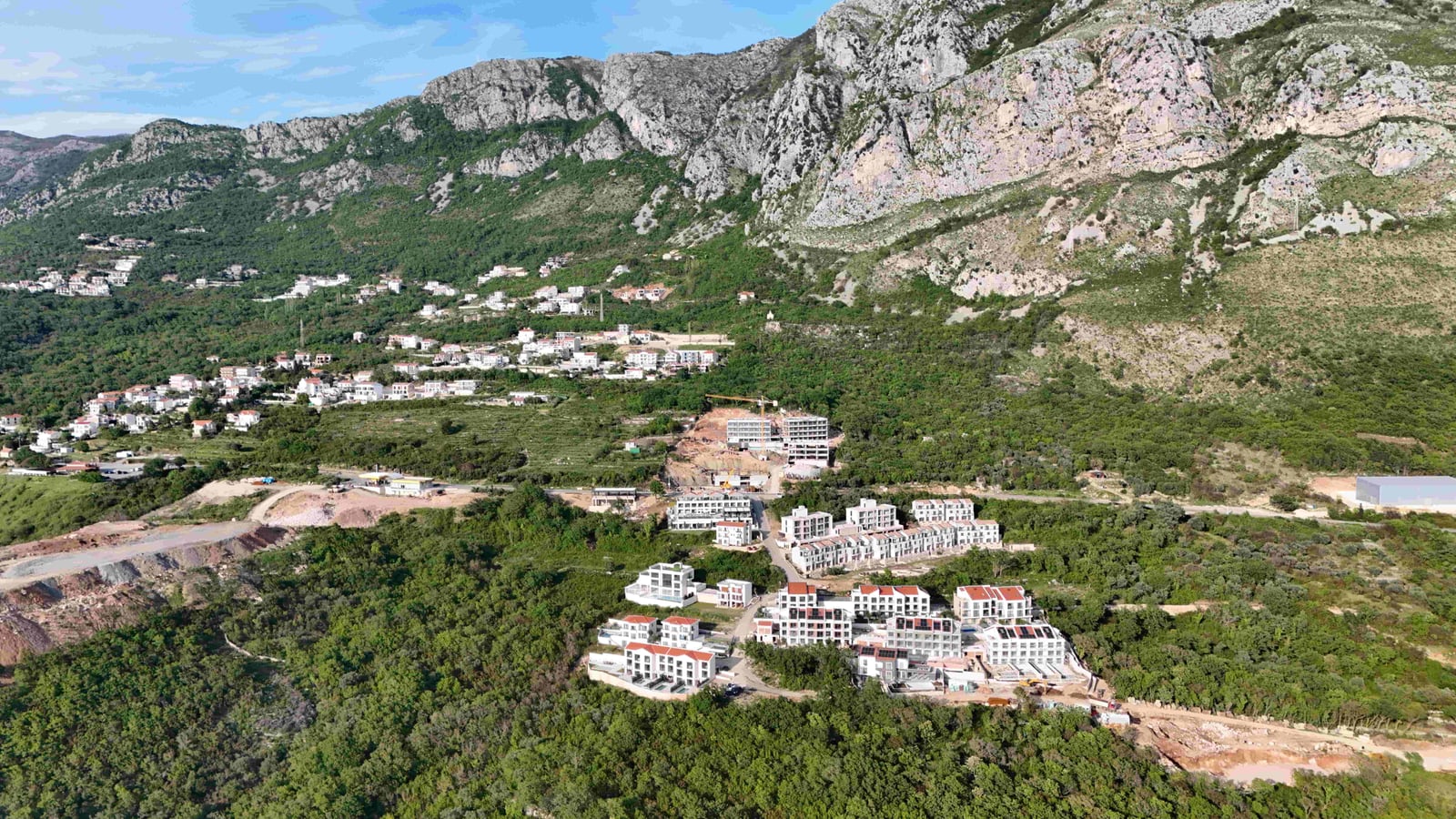 Aerial view of a residential complex under construction in the Markovići mountains, Montenegro: land plot and panoramic landscape.