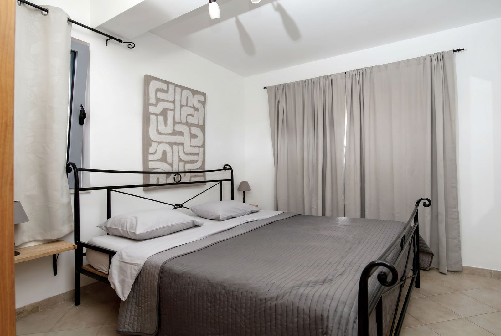Bedroom with a double bed in an apartment in Risan, Montenegro: modern interior, light tones, and wall decor.