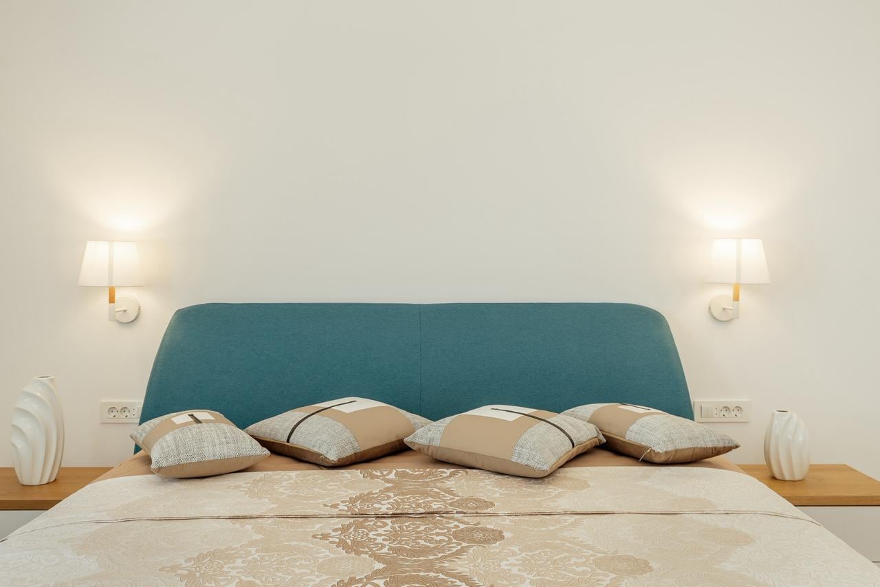 Modern bedroom with a double bed and a blue headboard in an apartment, Igalo, Montenegro.