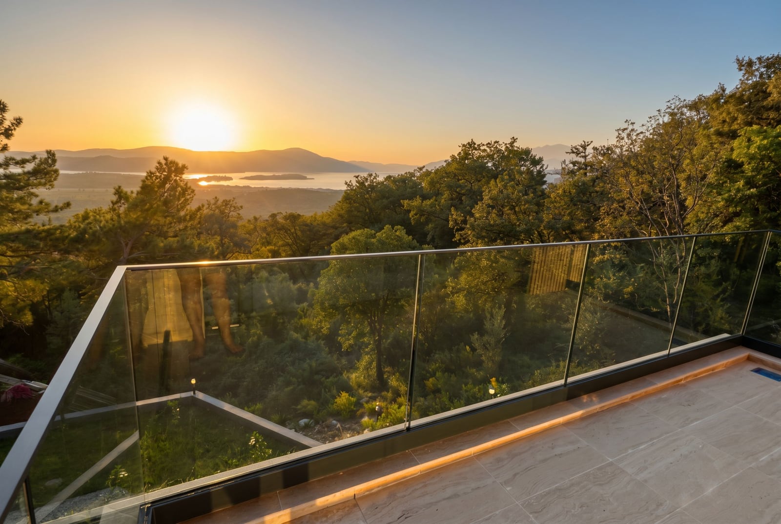 Villa terrace in Kavac, Montenegro: glass railing, panoramic sunset view, sea and mountains, modern finishes.