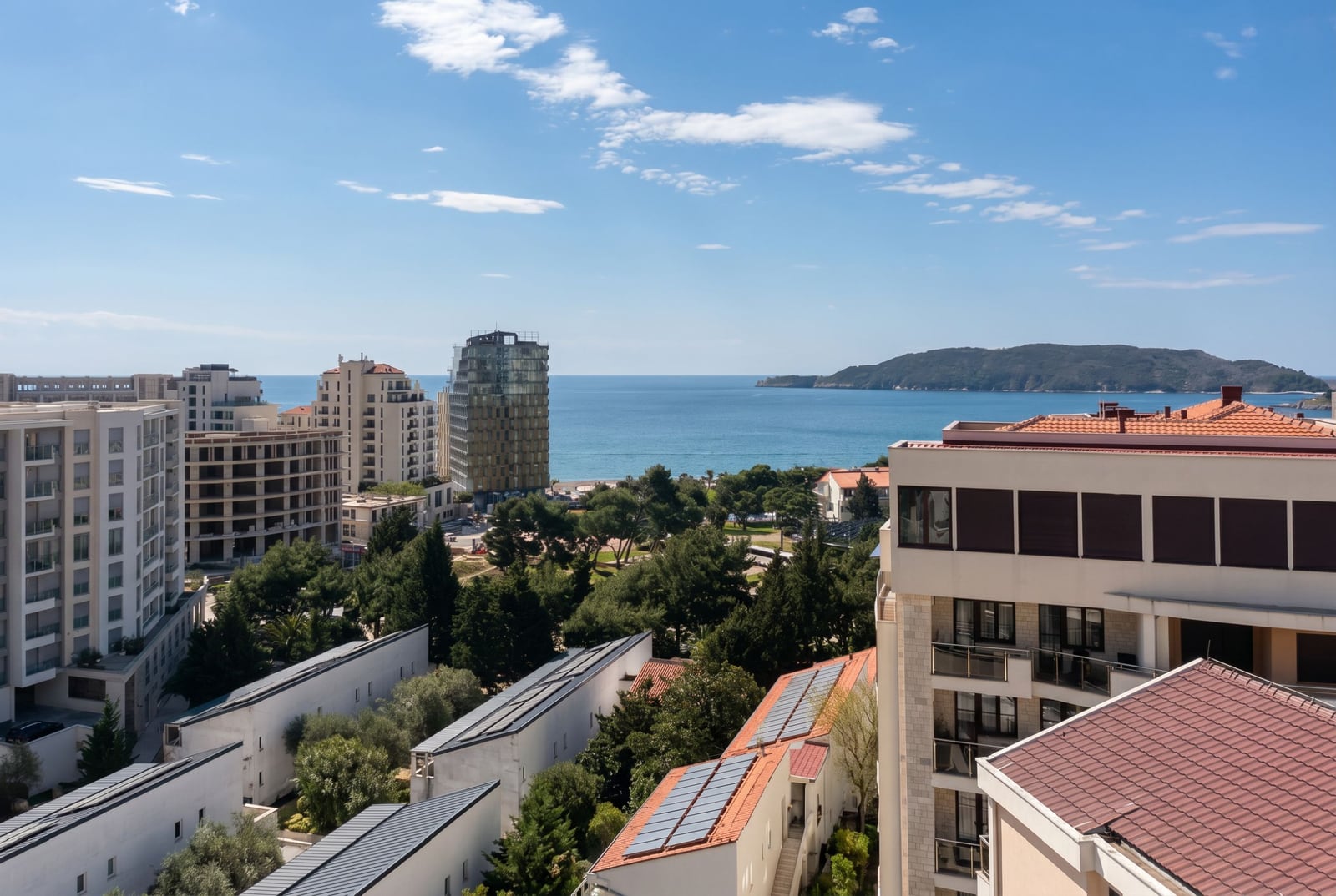 Panoramic sea view and residential complex in Bečići, Montenegro: modern buildings, greenery, and seascape.