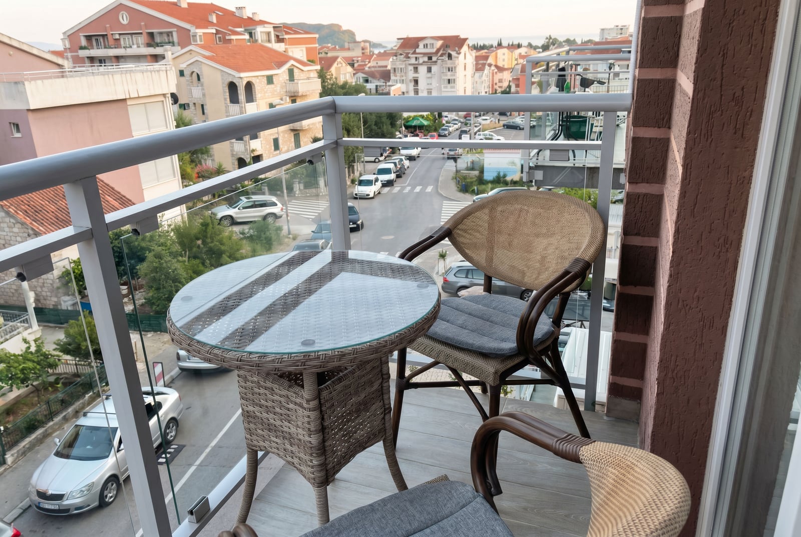 Cozy balcony with wicker furniture and a city view in an apartment in Budva, Montenegro.