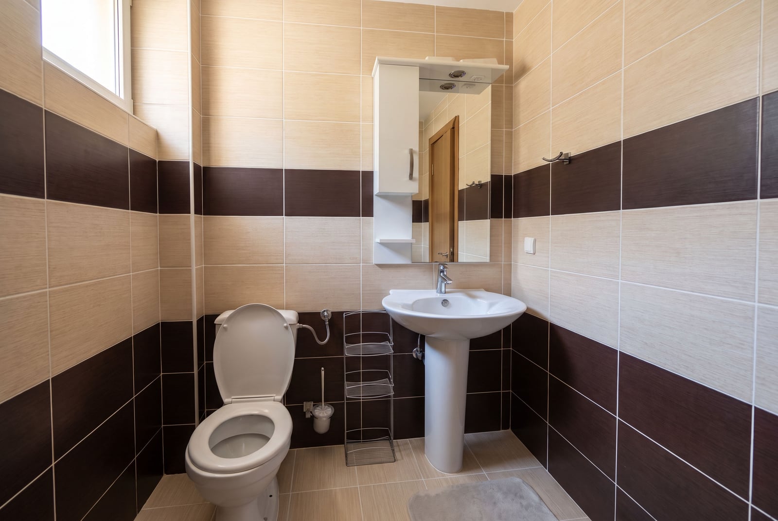 Modern bathroom in an apartment in Tivat, Montenegro: white fixtures, pedestal sink, mirrored cabinet, and a...