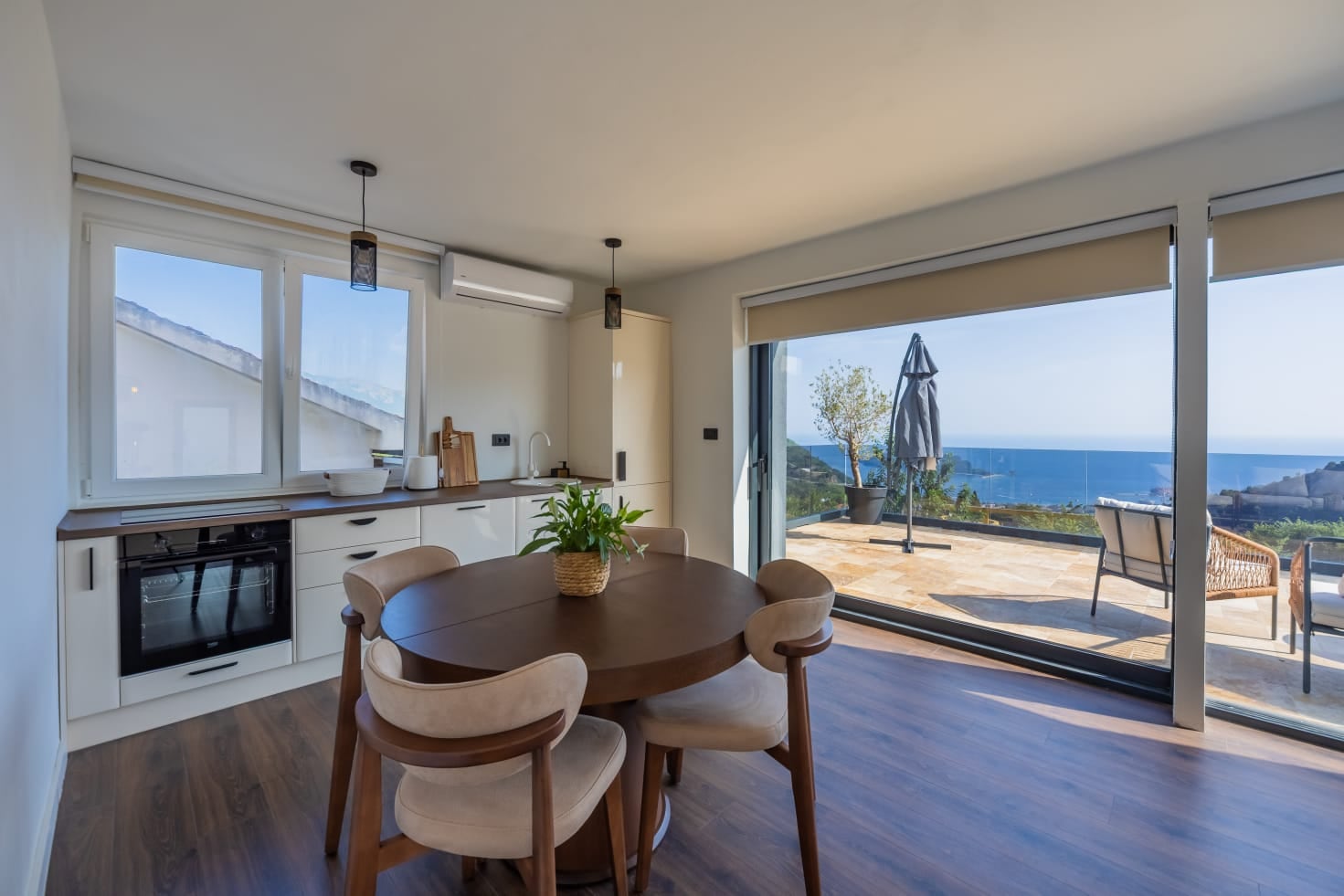 Modern kitchen-dining room in a villa in Budva, Montenegro, with panoramic sea views and access to the terrace.