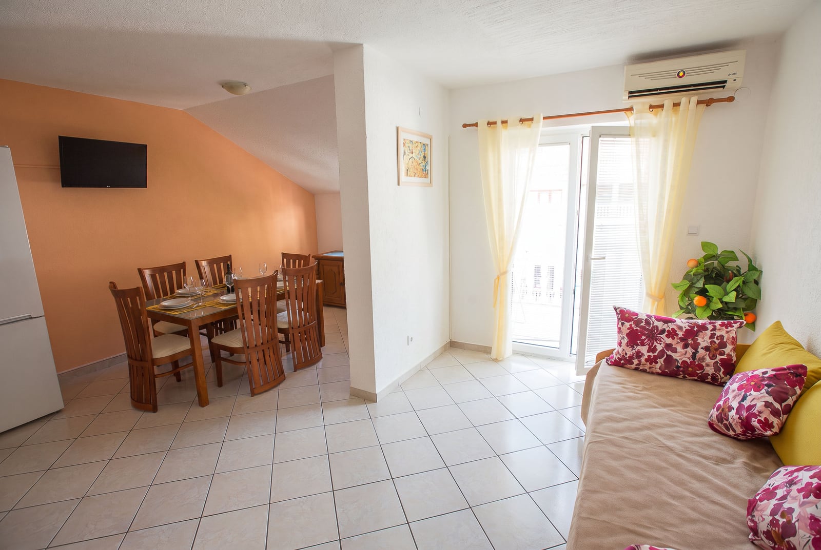 Spacious living room with dining area, wooden table, and sofa in an apartment in Budva, Montenegro