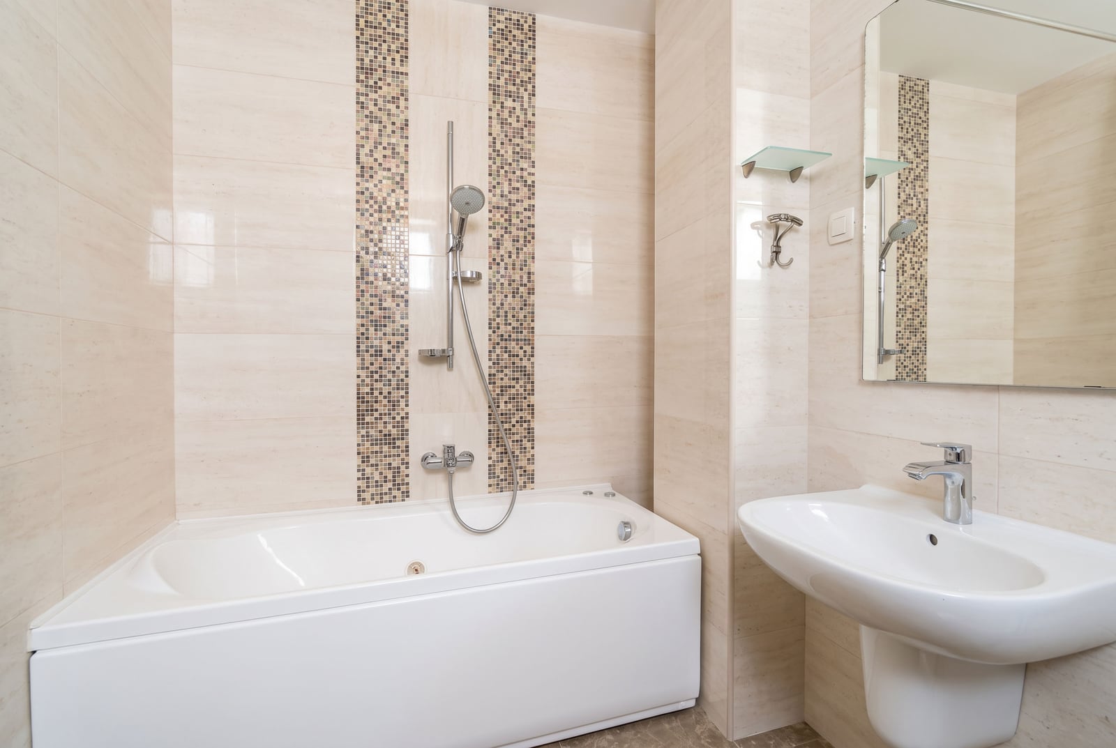 Modern bathroom with a white bathtub, sink, and mosaic tiles in an apartment in Bečići, Montenegro.