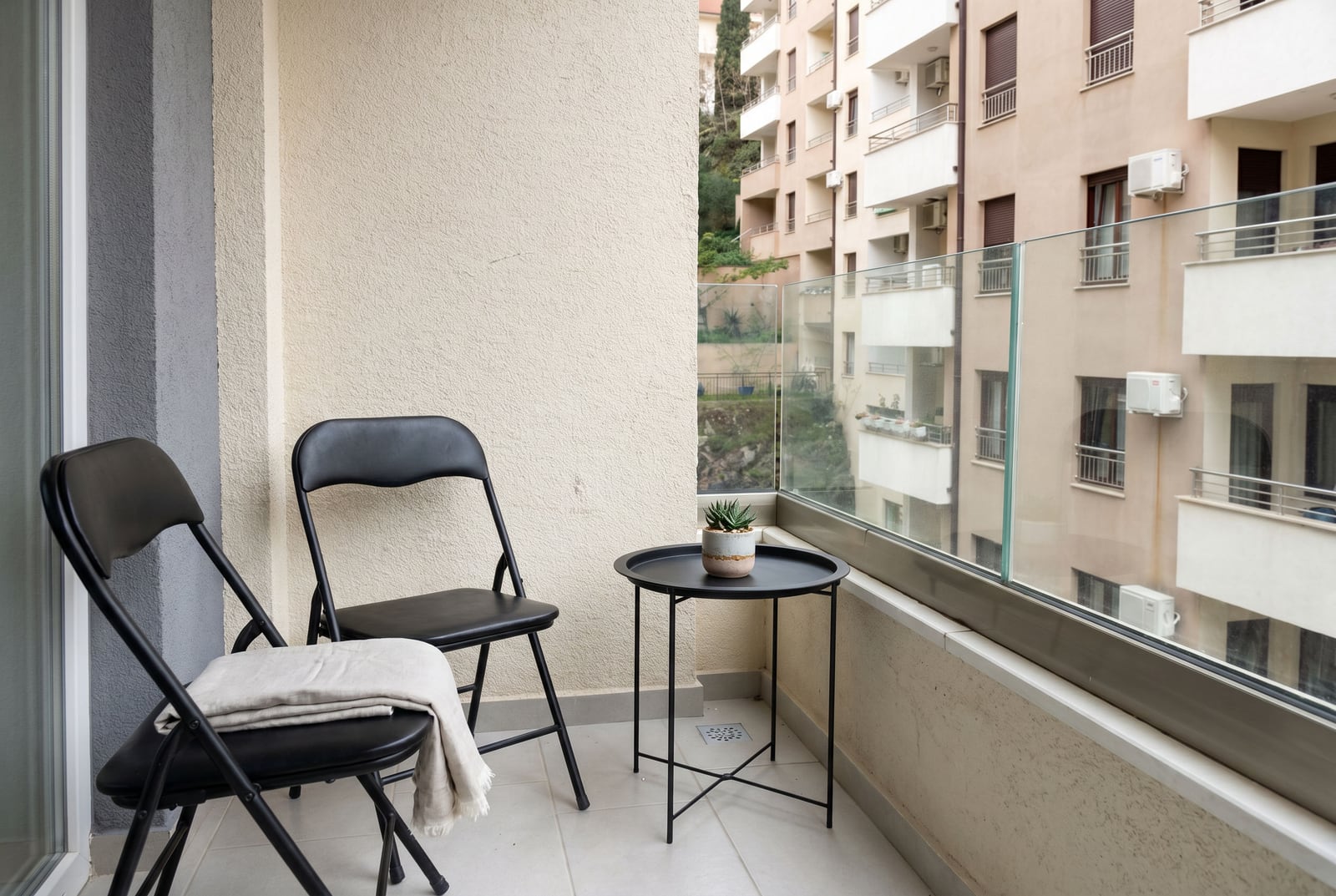 Balcony with black furniture and glass railing in an apartment, Bečići, Montenegro.