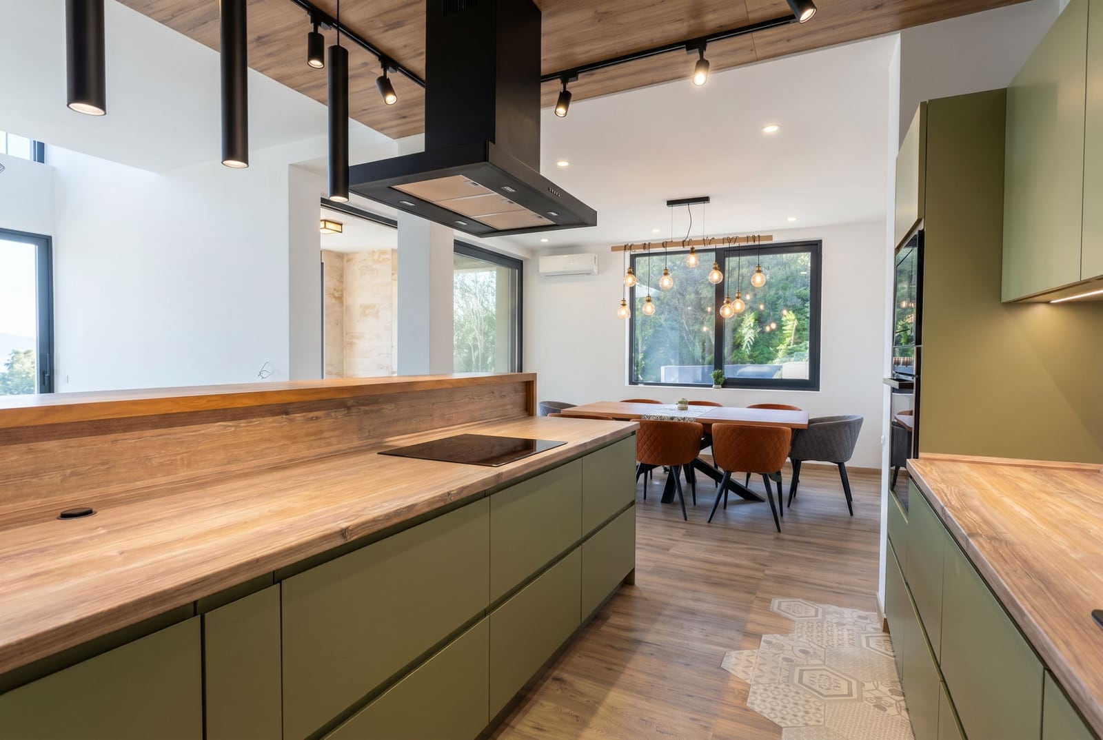 Modern kitchen with island and dining area in a villa in Kavac, Montenegro: stylish interior, nature view.