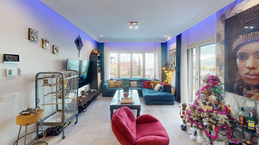 Cozy living room with a blue sofa and panoramic windows in a townhouse, Luštica, Montenegro. Modern interior with decor.