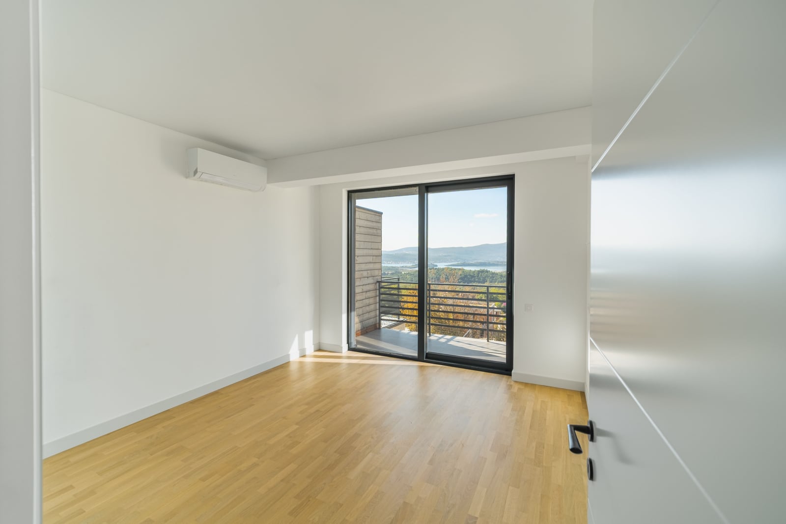 Bright bedroom in a townhouse, Kavač, Montenegro: parquet flooring, panoramic window with mountain views and a balcony, air conditioning.