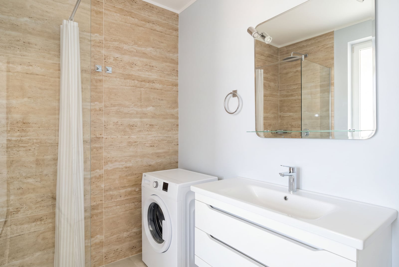 Modern bathroom with a shower cabin and washing machine in an apartment, Bečići, Montenegro.