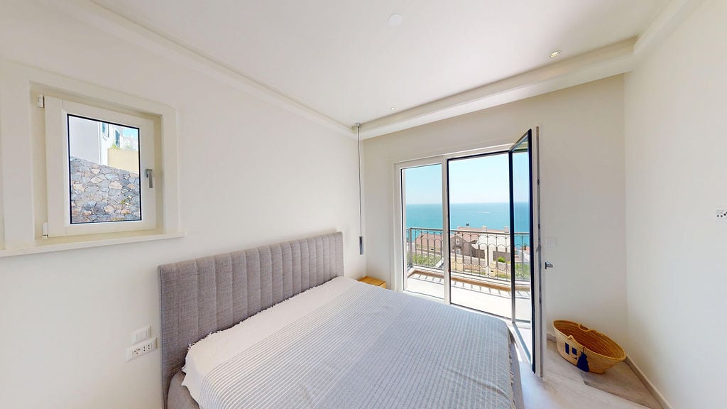 Bright bedroom with a double bed and panoramic sea view in a residential complex, Luštica, Montenegro.