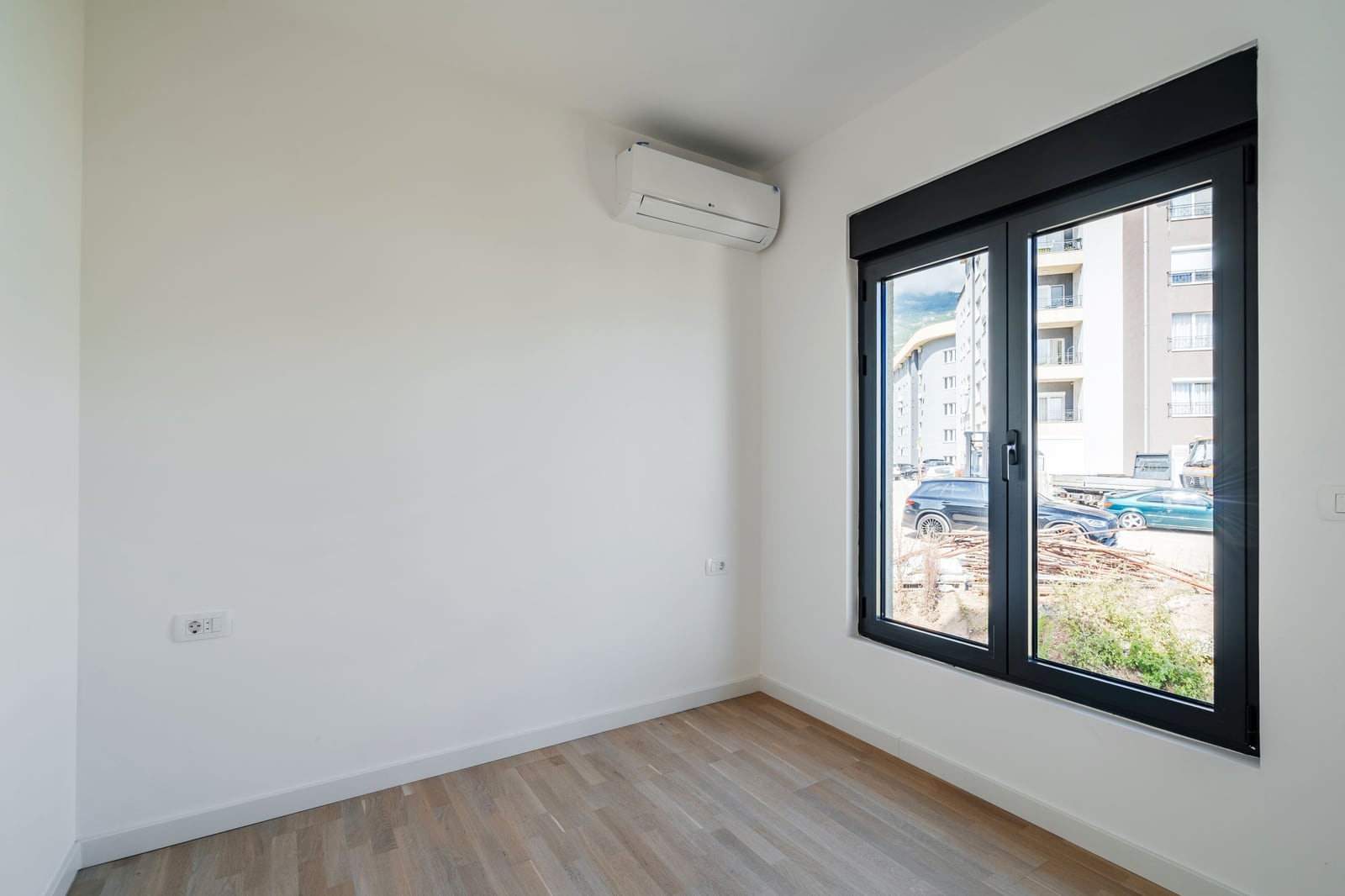 Bright bedroom with air conditioning and a panoramic window in a new residential complex in Budva, Montenegro.