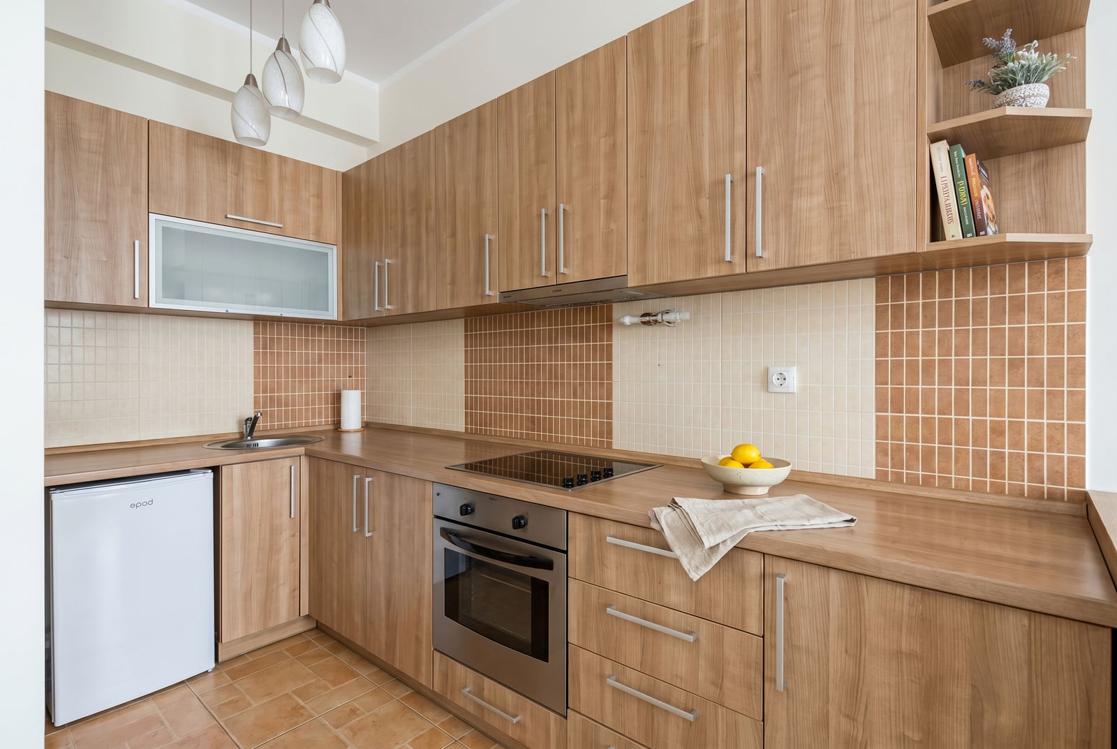 Modern kitchen with wooden cabinets and built-in appliances in an apartment for sale, Budva, Montenegro.