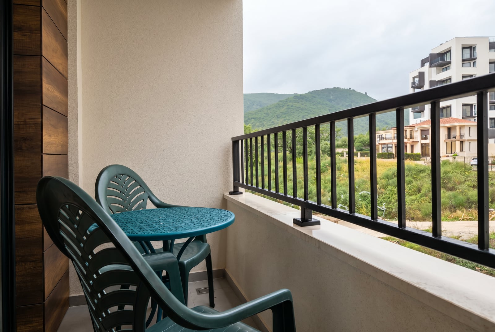Balcony with plastic furniture and mountain views in an apartment, Becici, Montenegro.
