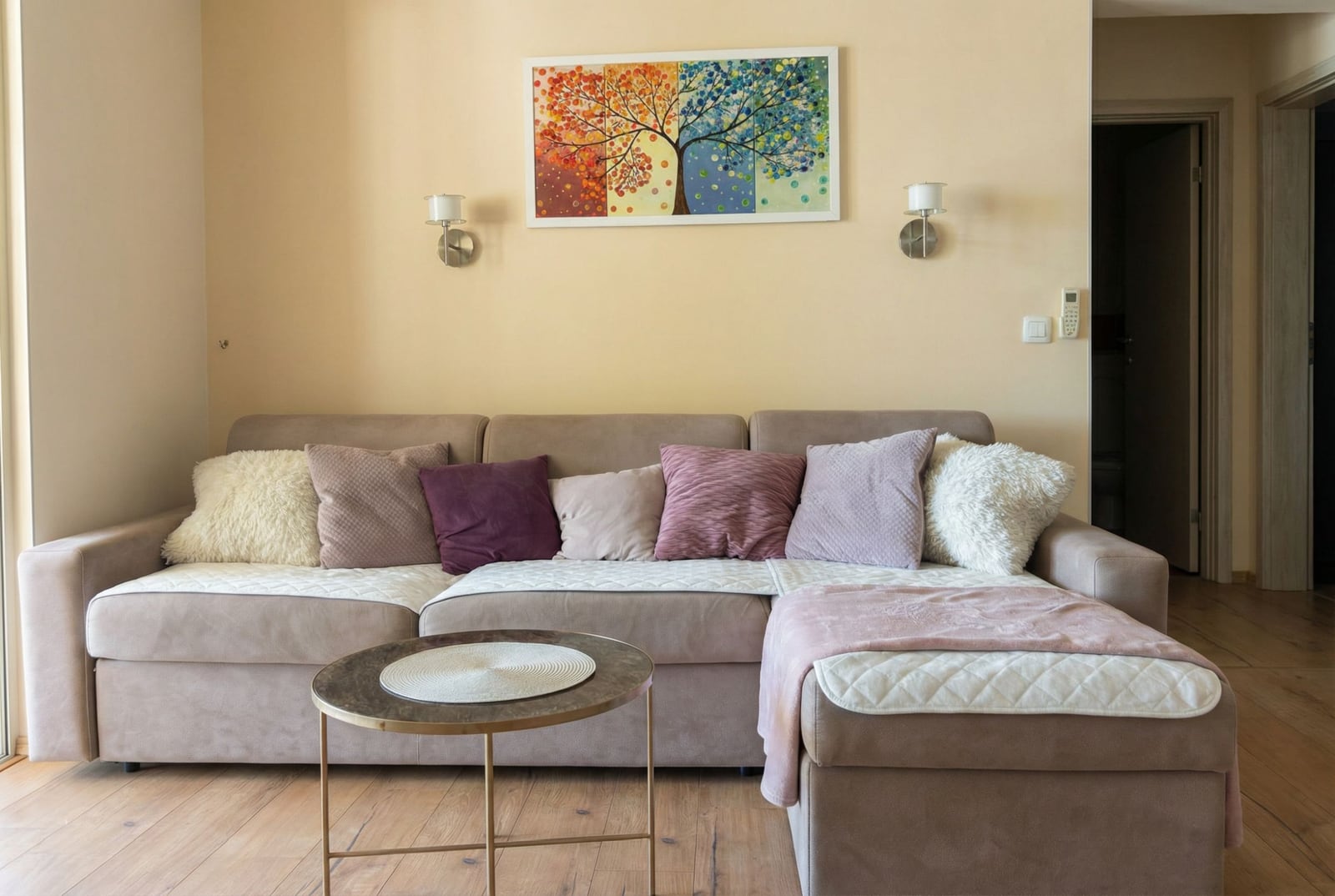 Cozy living room in an apartment in Pržno, Montenegro: beige corner sofa, coffee table, and a painting on the wall.