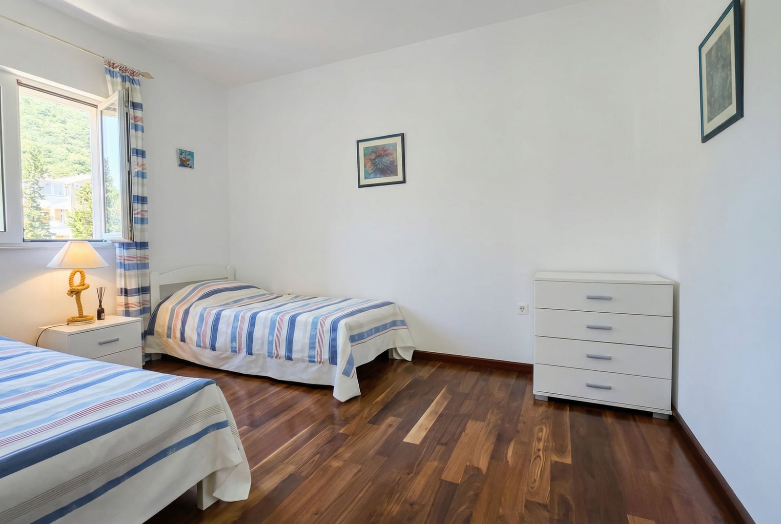 Bright bedroom with two beds, parquet flooring, and mountain views in an apartment for sale, Tivat, Montenegro.