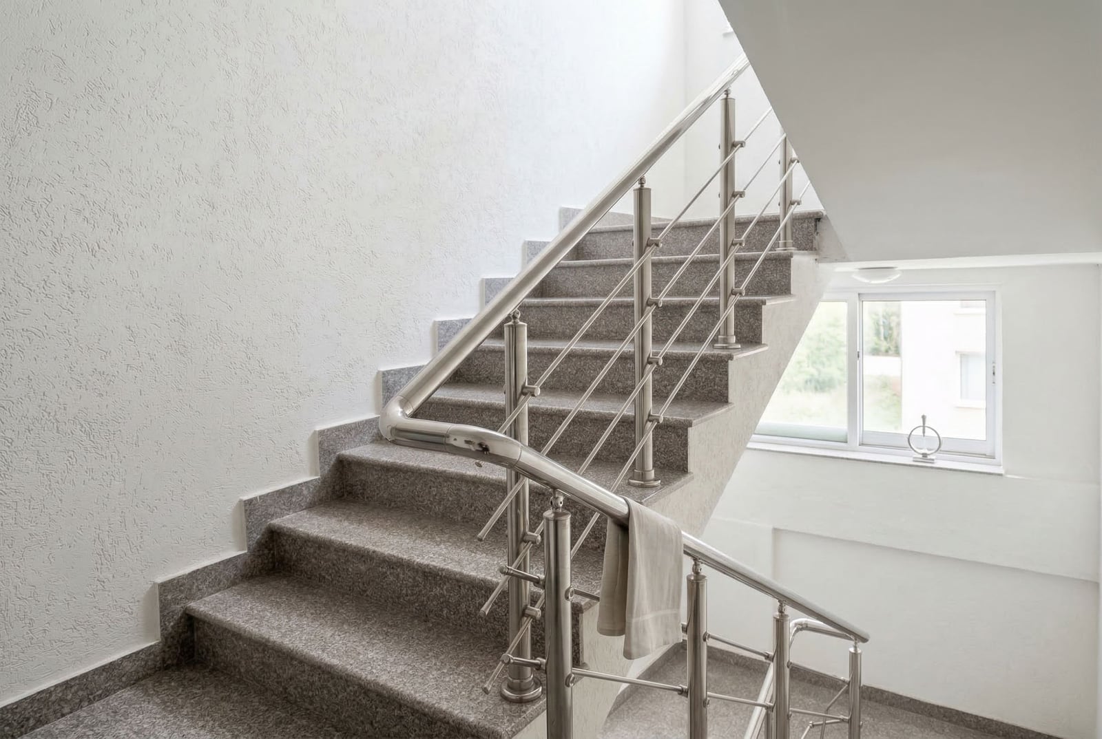 Staircase with granite steps and metal railings in a residential building, Budva, Montenegro.