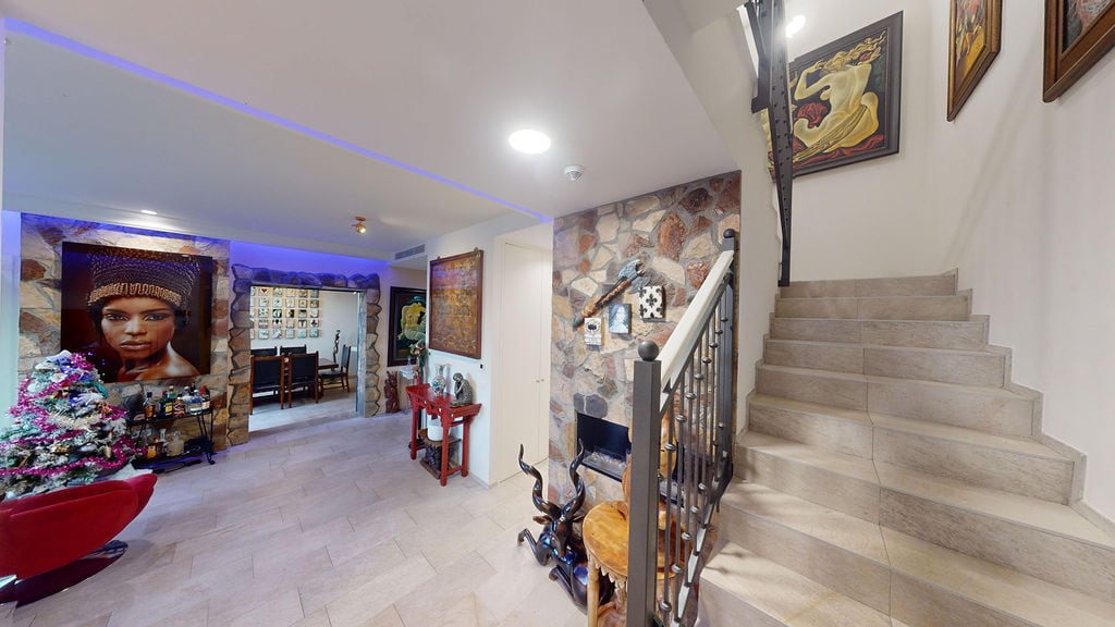 Interior of a living room with stone finishing, fireplace, and staircase in a townhouse, Luštica, Montenegro.