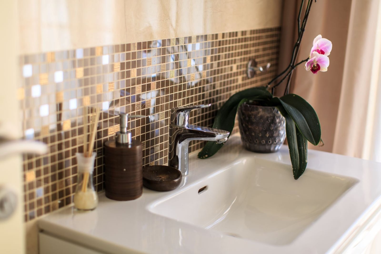 Modern bathroom with mosaic tiles and a white sink in a villa in Tivat, Montenegro.