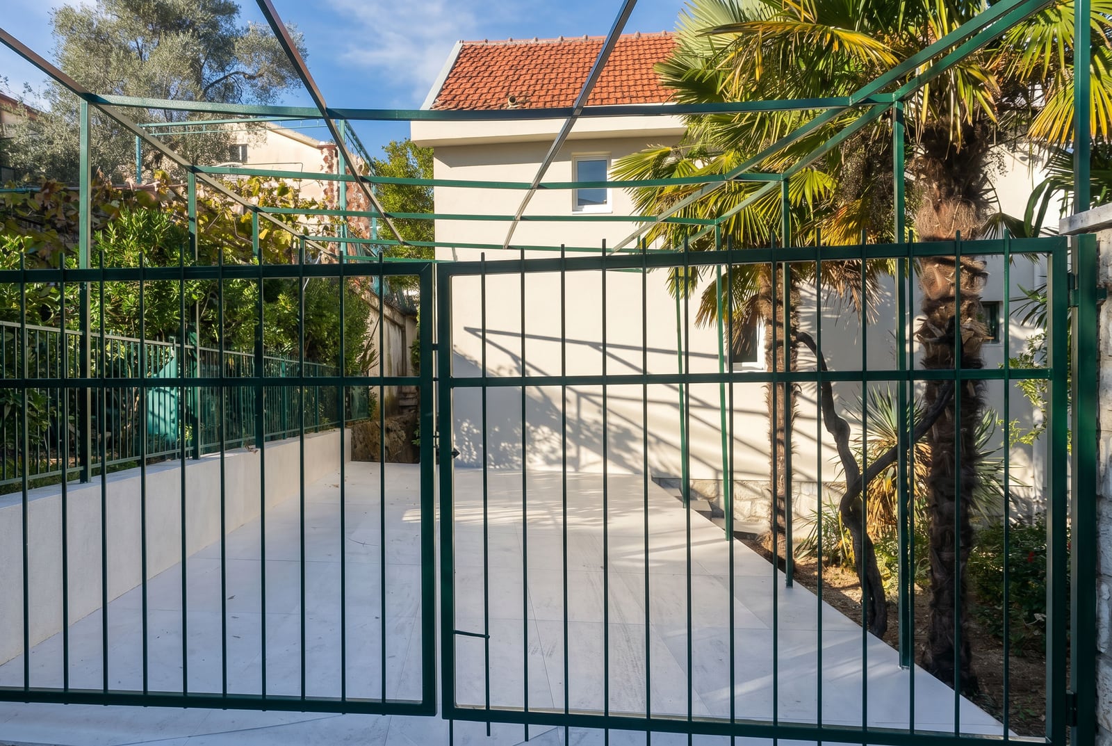 Private parking space with a canopy and metal gates at a house in Krašići, Montenegro.