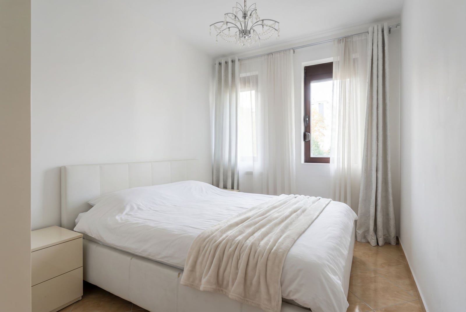 Bright bedroom with a double bed in an apartment, Rafailovici, Montenegro: modern interior, tiled floor.