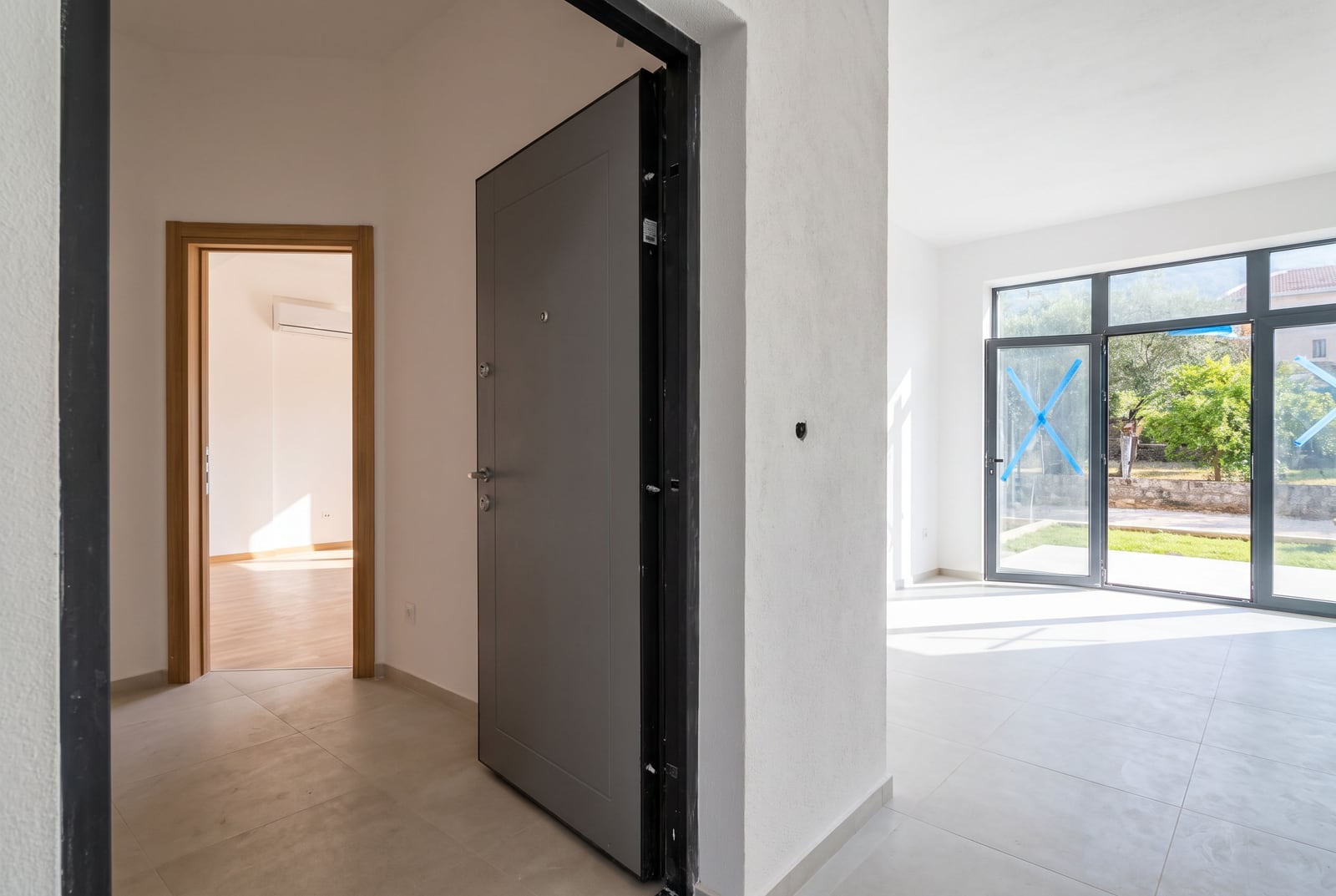 Entrance hall and bright living room with panoramic windows in a new apartment in the city of Bar, Montenegro.