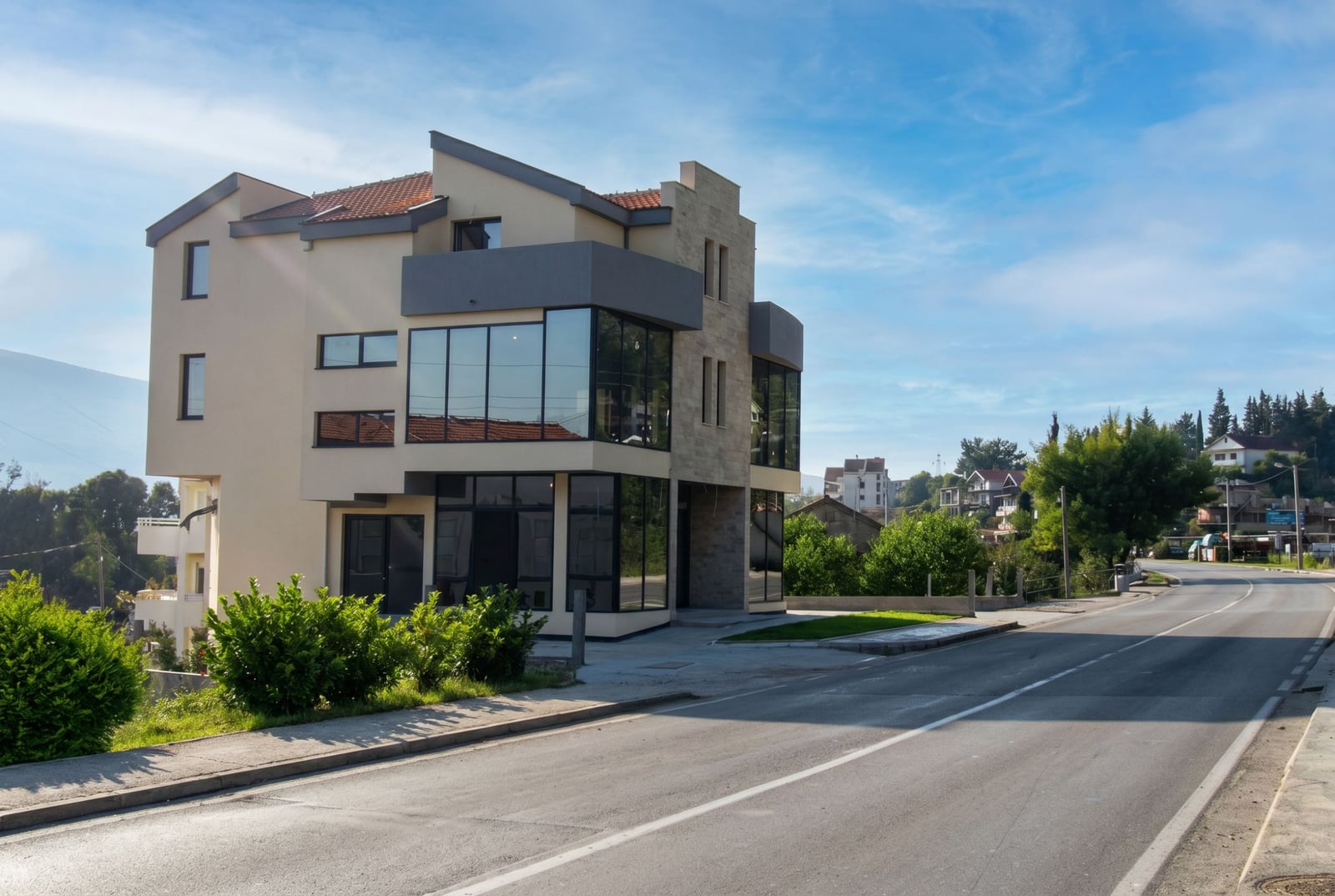 Modern office building with panoramic glazing in Baošići, Herceg Novi, Montenegro: road view.