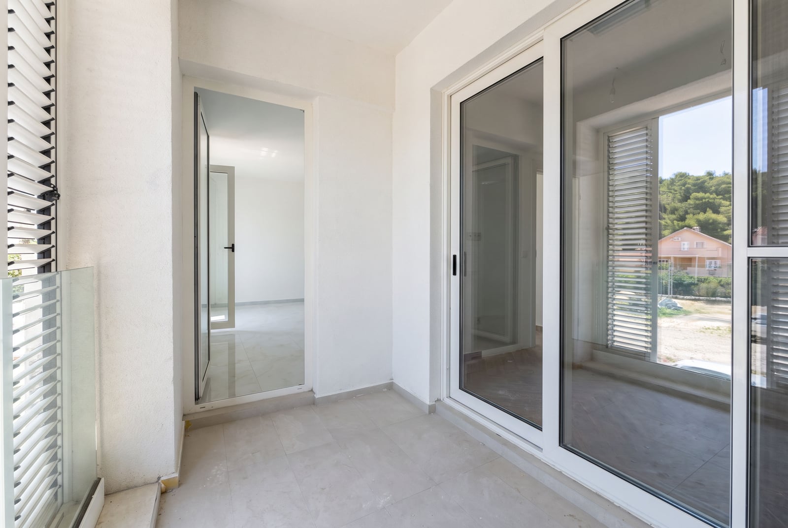 Bright balcony with panoramic glazing and mountain views in a new apartment in Tivat, Montenegro.