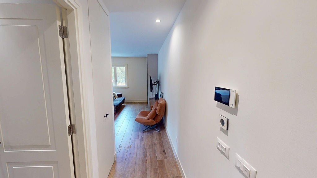Corridor and living room in a modern apartment, Luštica, Montenegro: light finishes, parquet flooring, and a smart home system.