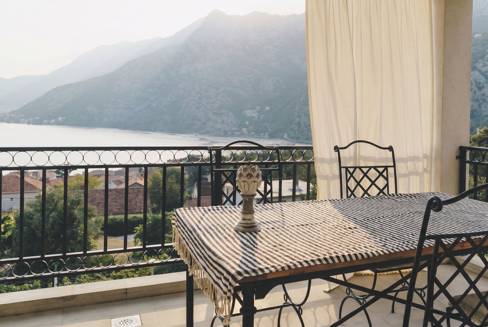 Balcony with wrought iron furniture and a view of the Bay of Kotor and mountains, apartment in Risan, Montenegro.