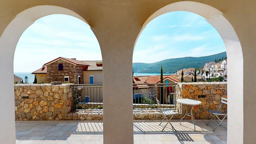 Stone-finished terrace with sea and mountain views in the Luštica residential complex, Montenegro.