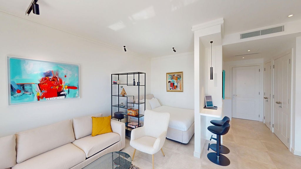 Modern living room with a bedroom area in an apartment, Luštica, Montenegro: bright interior, sofa, and bar counter.