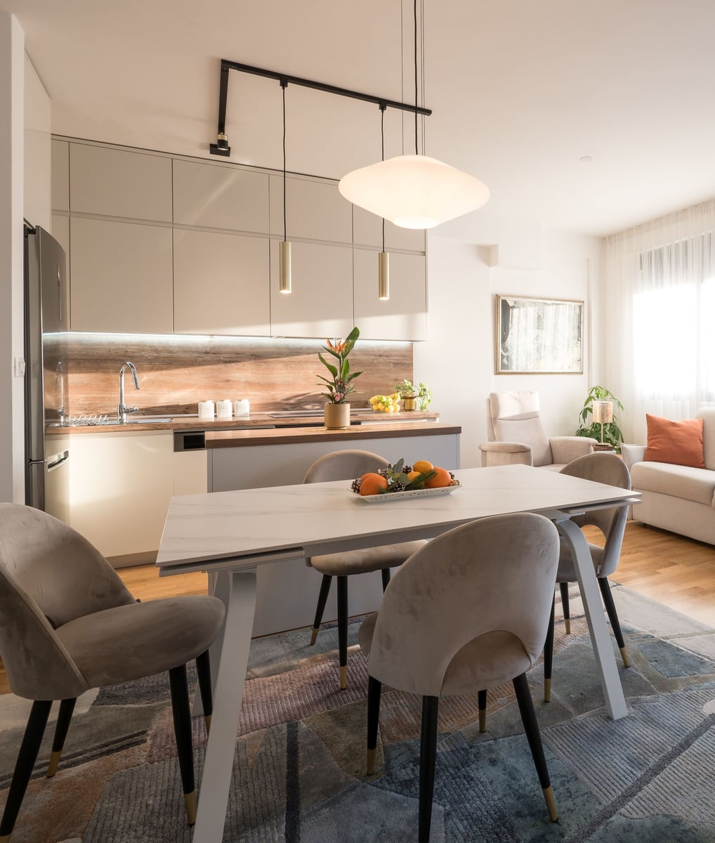 Modern kitchen and living room in a Tivat apartment, Montenegro: light-colored furniture, dining area, and stylish interior.