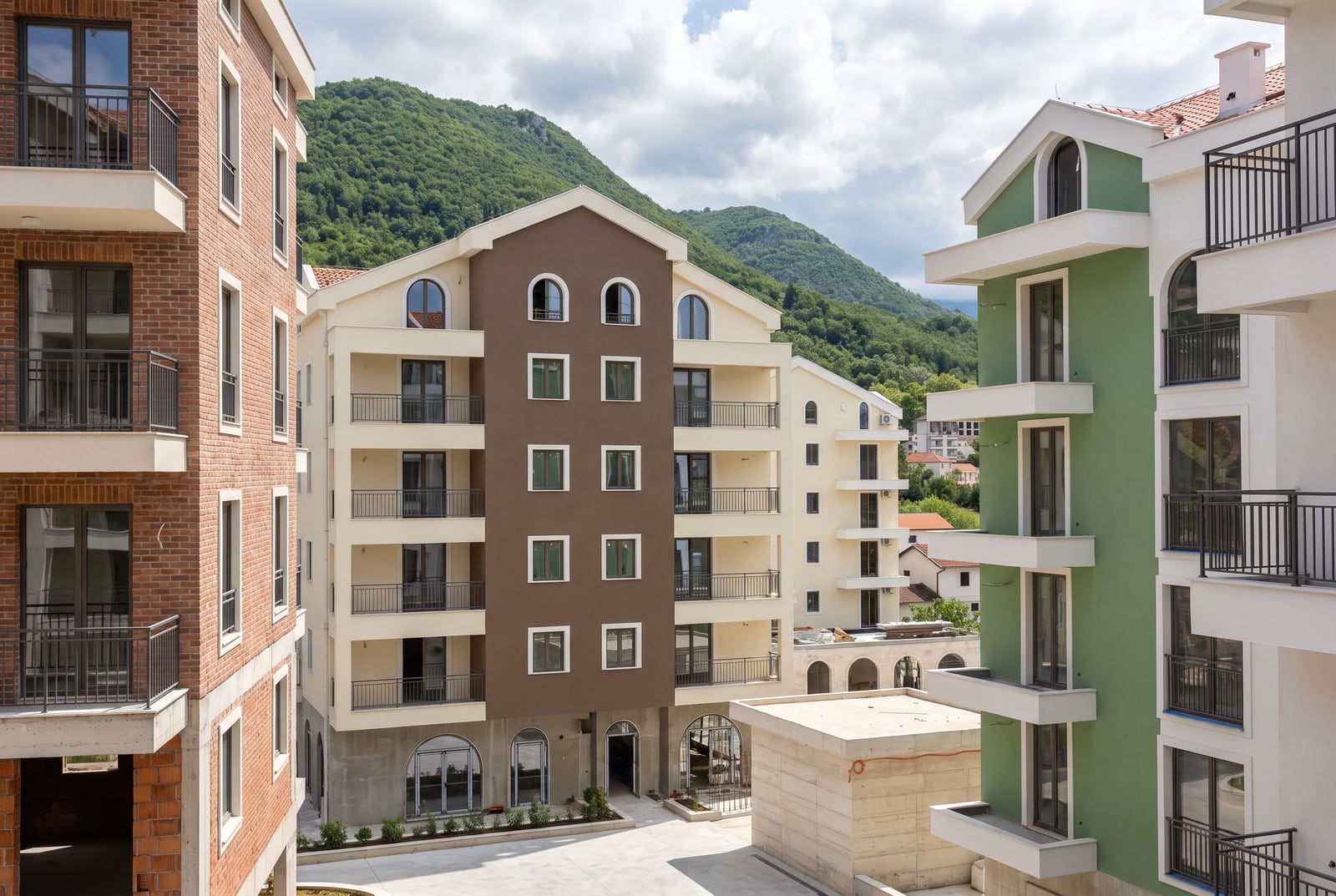 Modern residential complexes with balconies and views of the green mountains in Tivat, Montenegro