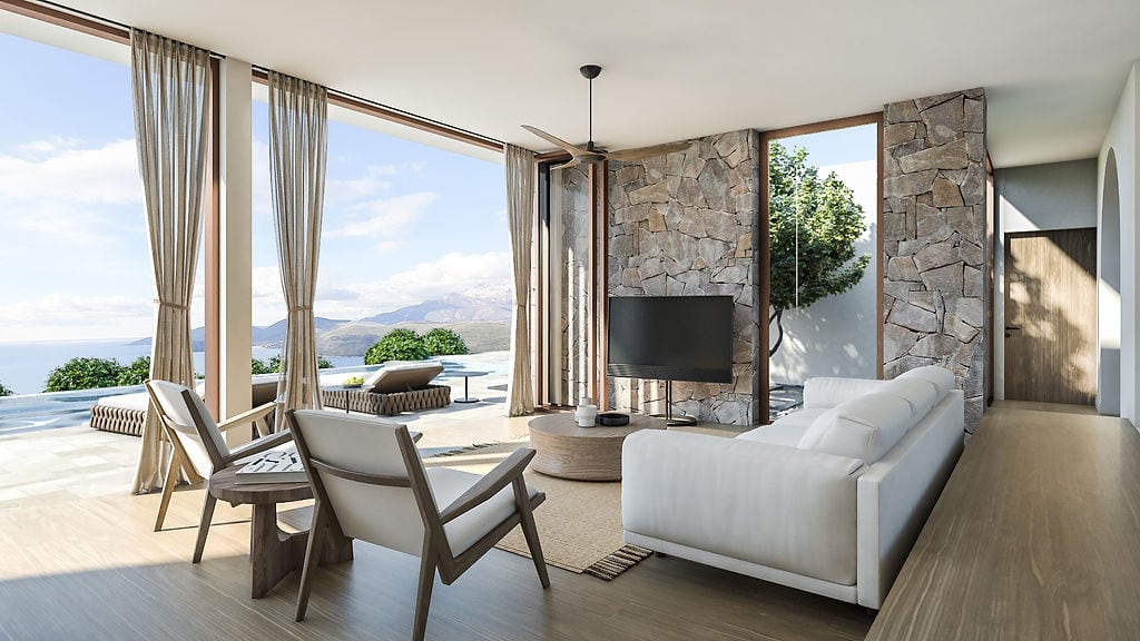 Living room of a villa in Luštica, Montenegro: panoramic windows, sea view, stone wall cladding, and modern furniture.
