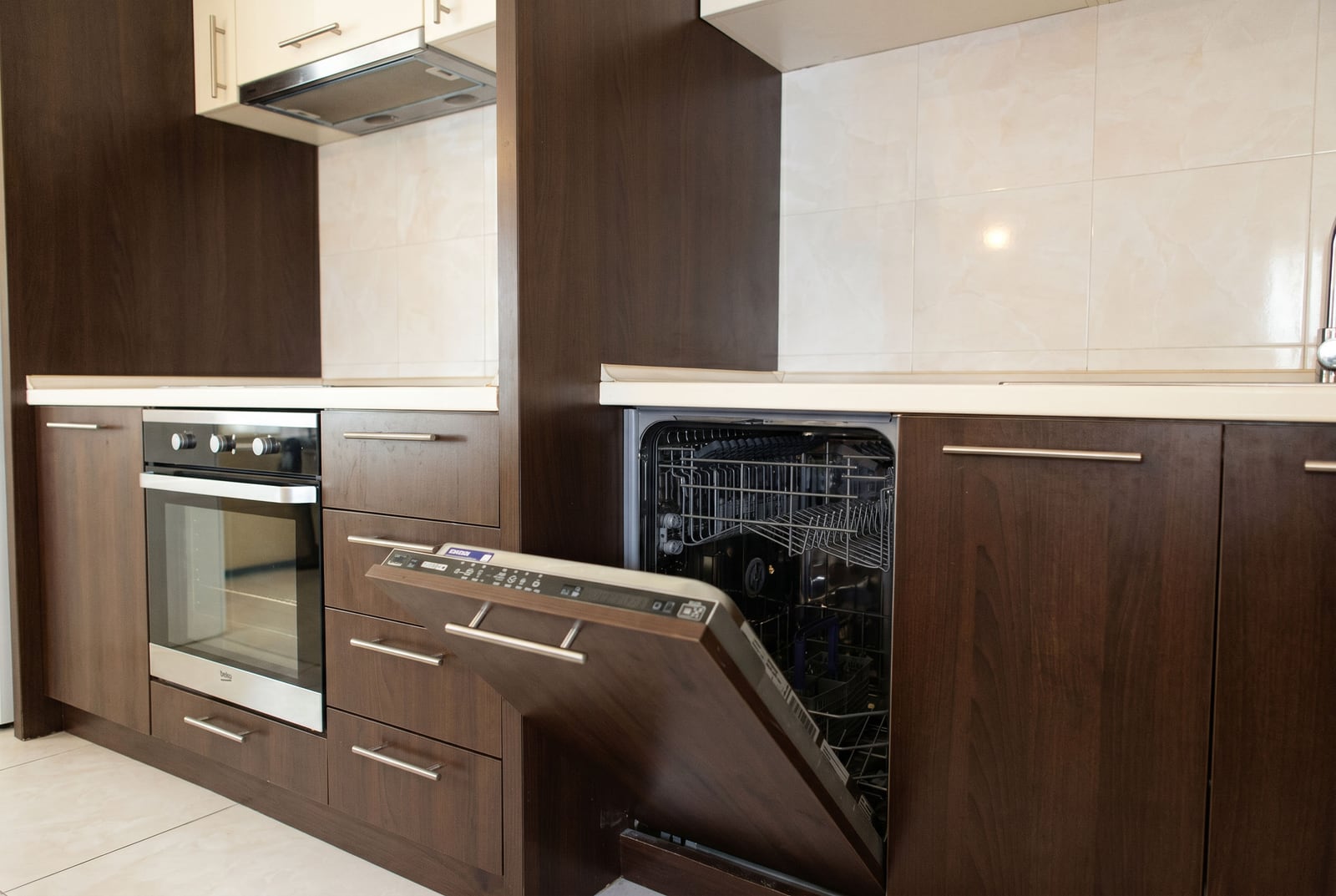 Modern kitchen in an apartment in Bečići, Montenegro: dark cabinetry, built-in oven, and dishwasher.