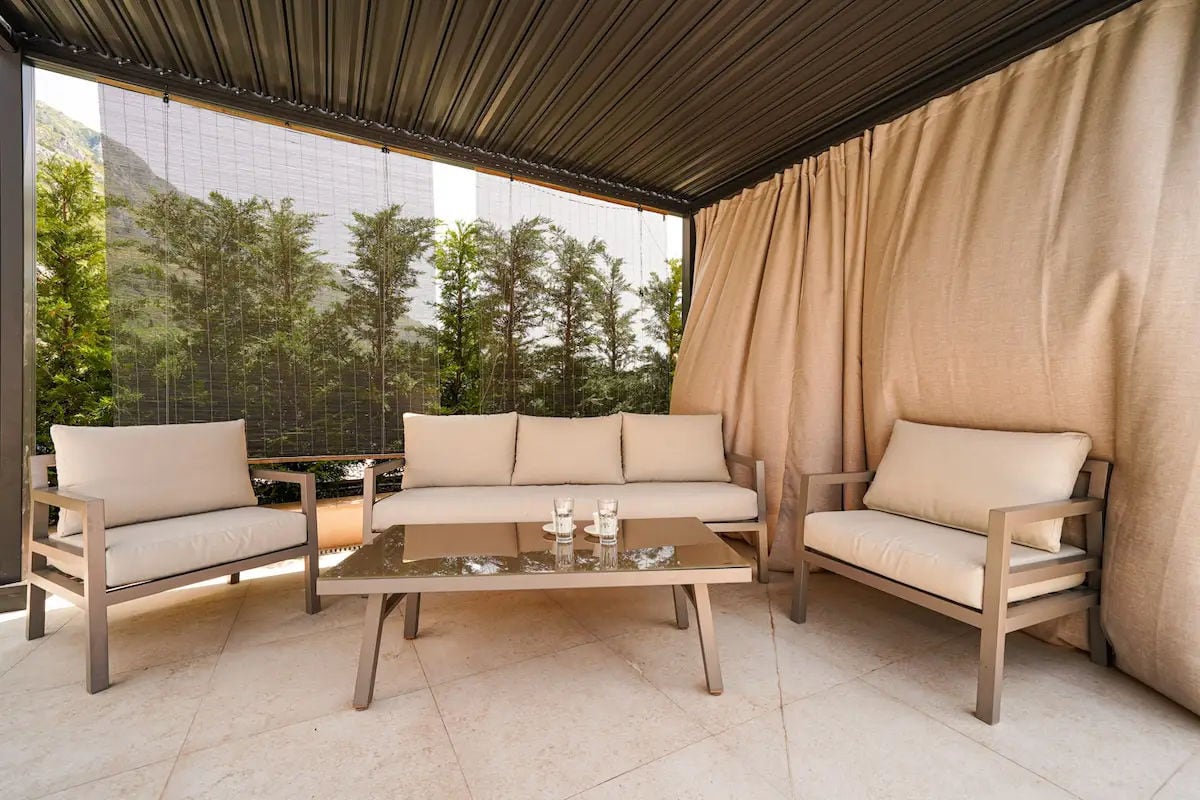 Cozy terrace with comfortable furniture and mountain views at a villa in Reževići, Montenegro. Modern lounge area on the balcony.