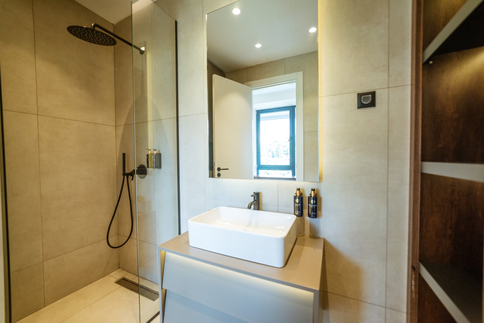 Modern bathroom in an apartment in Bečići, Montenegro: shower cabin, countertop sink, and stylish finishes.