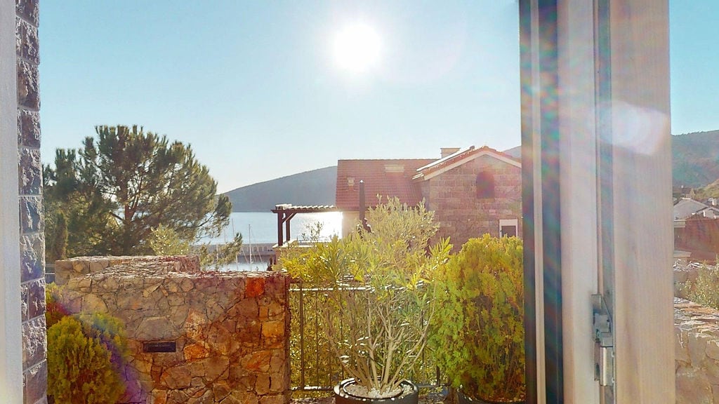 View from the terrace overlooking the sea and yacht marina in the Luštica residential complex, Montenegro: stone finishing and Mediterranean plants.