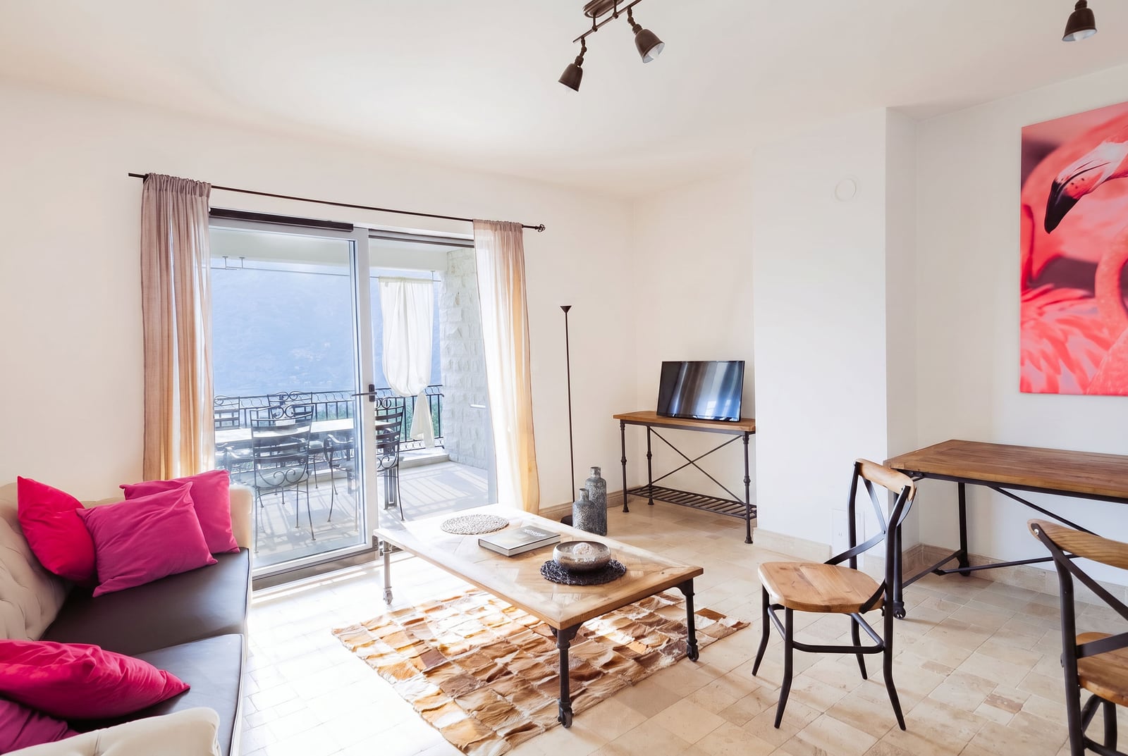 Bright living room with wooden furniture and access to a terrace with mountain views in an apartment, Risan, Montenegro.