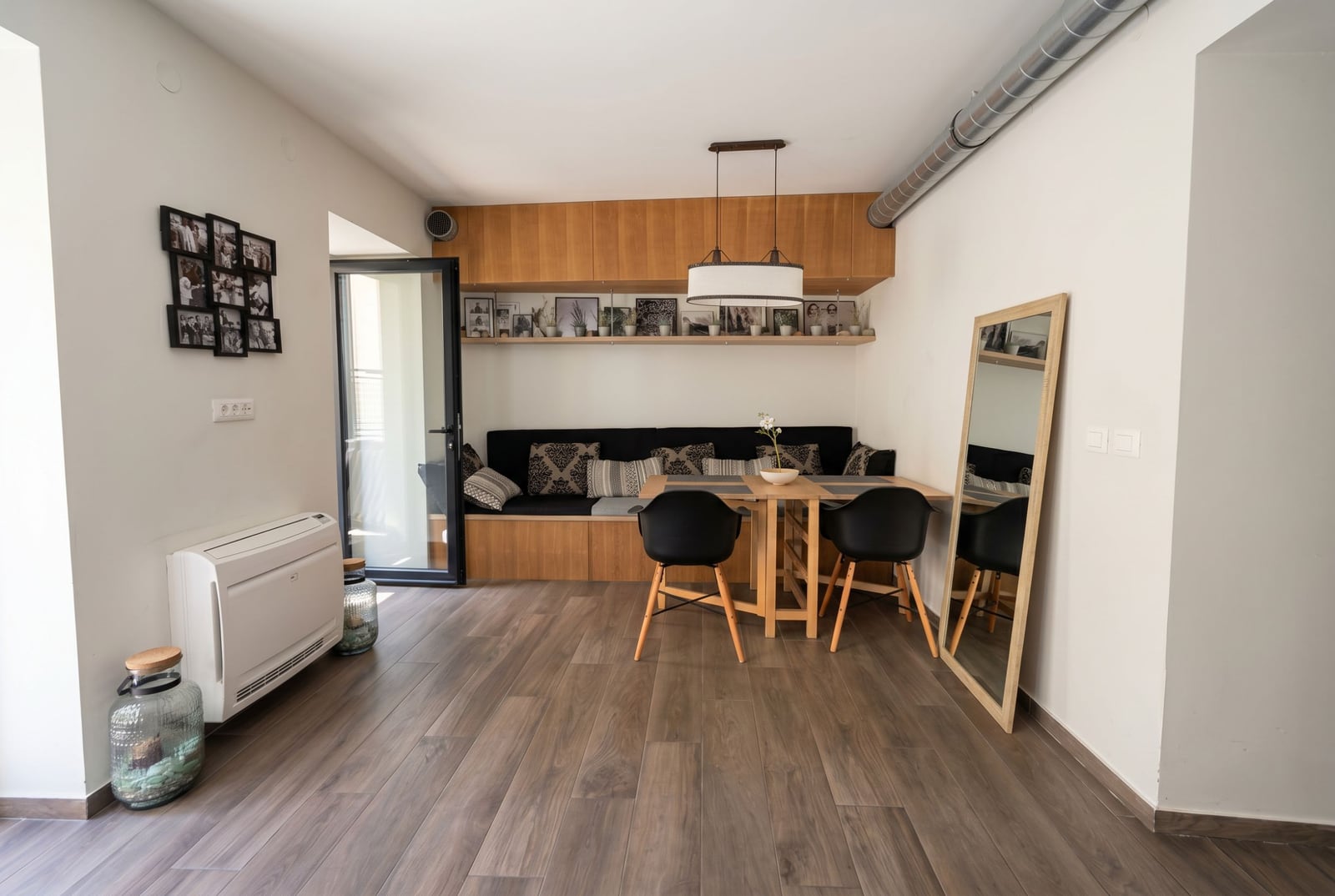 Modern living room with dining area in an apartment in Budva, Montenegro: wooden furniture, sofa, and stylish decor.