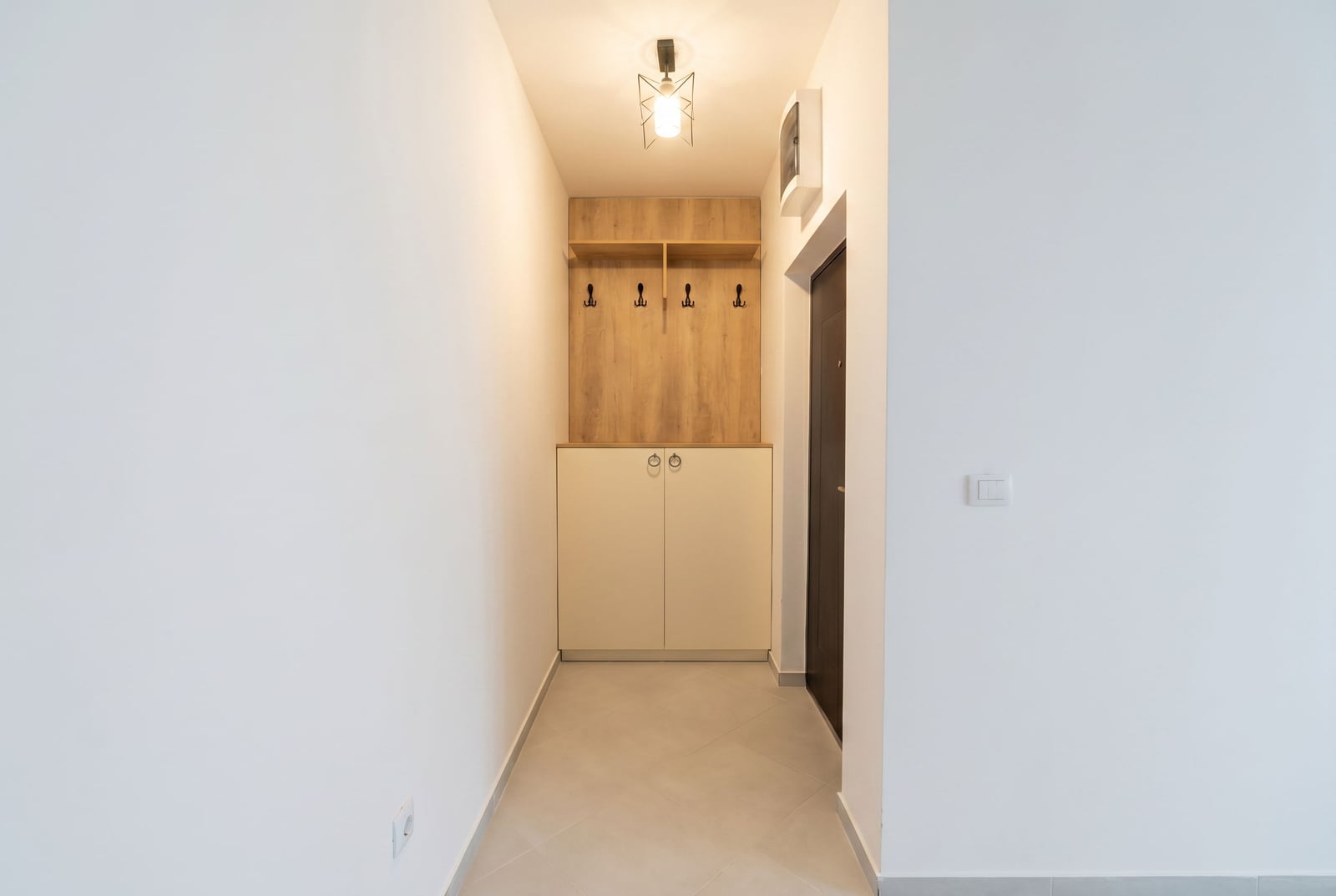 Bright hallway with a built-in wardrobe and coat rack in an apartment in Rafailovici, Montenegro. Modern interior.